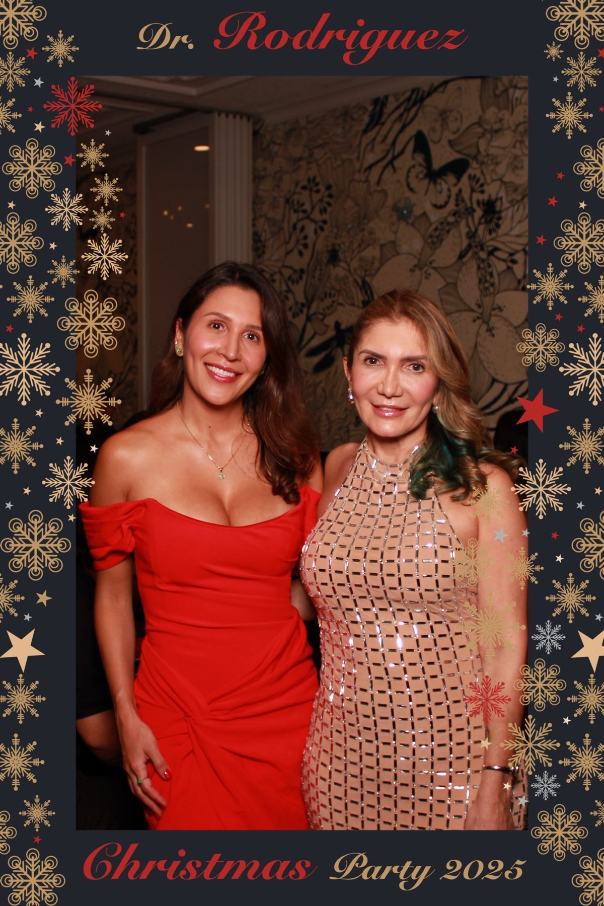 Two guests in evening wear posing with a festive custom overlay